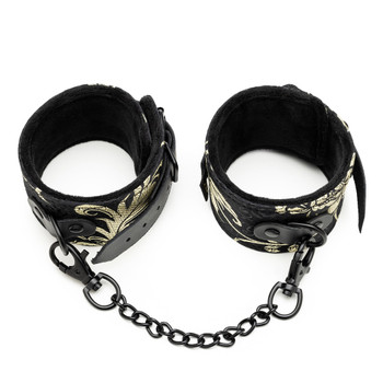 An overhead view of the Bonds of Desire Ankle Restraints connected by a short chain with clips on each end, on a white background